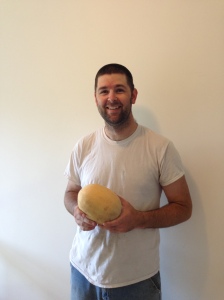 Chris with a cantaloupe from his garden.